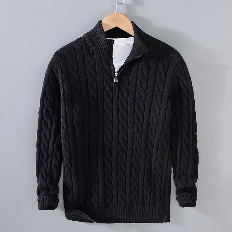 Maglione nero a trecce con zip, appeso su gruccia. Design elegante, ideale per moda invernale. Maglione uomo caldo e confortevole.