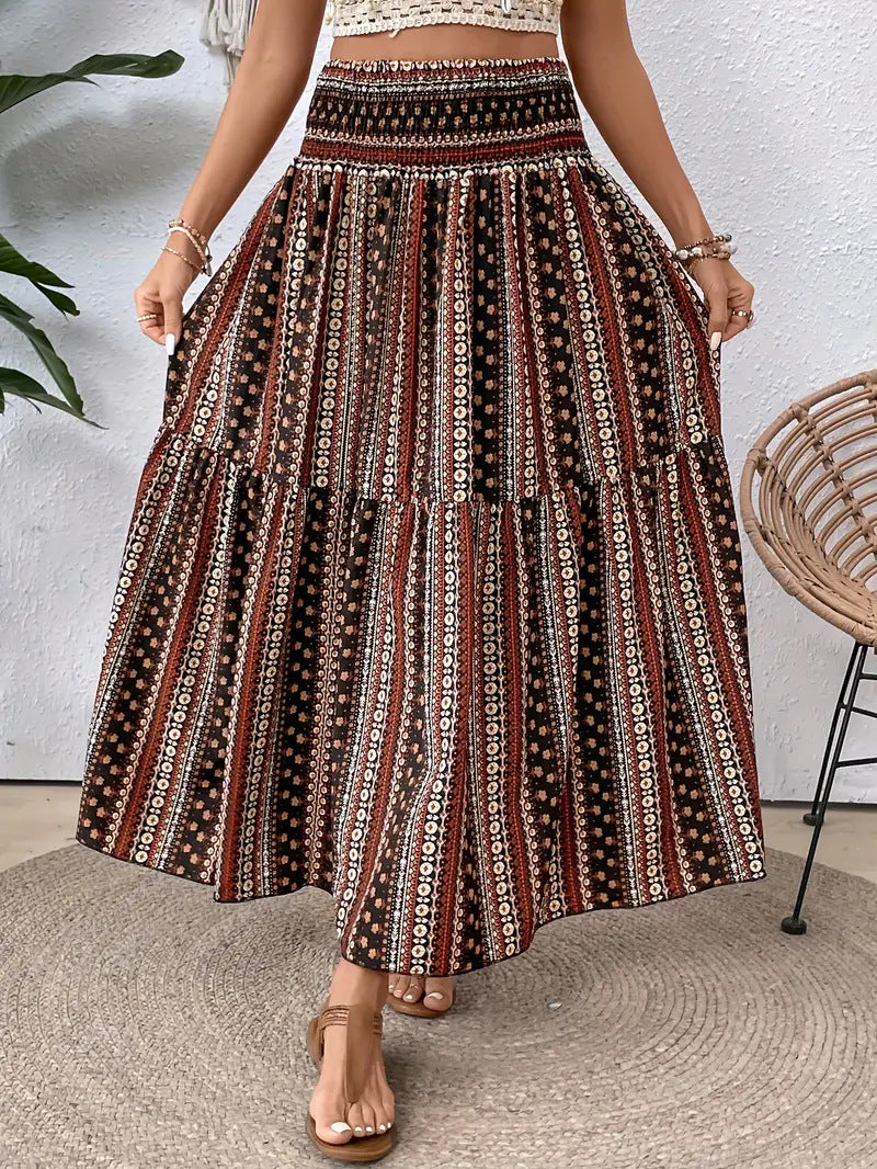 Gonna lunga boho a righe etniche, colori marrone e nero, con motivi floreali. Moda estiva donna, stile casual chic.