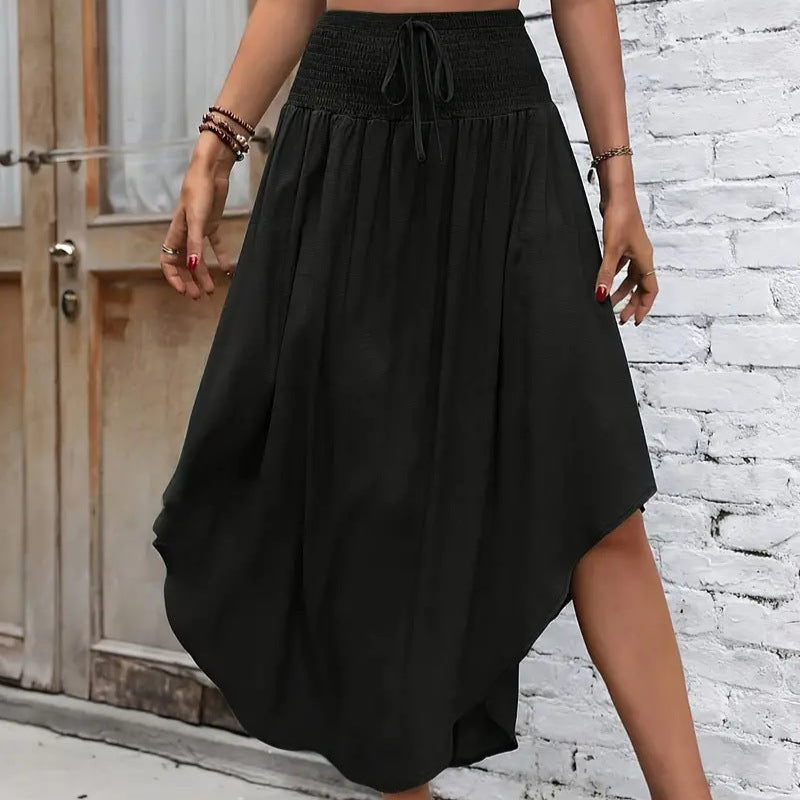 Gonna nera asimmetrica in cotone, lunghezza media, indossata da una donna. Design casual ed elegante, perfetta per look estivi e primaverili.