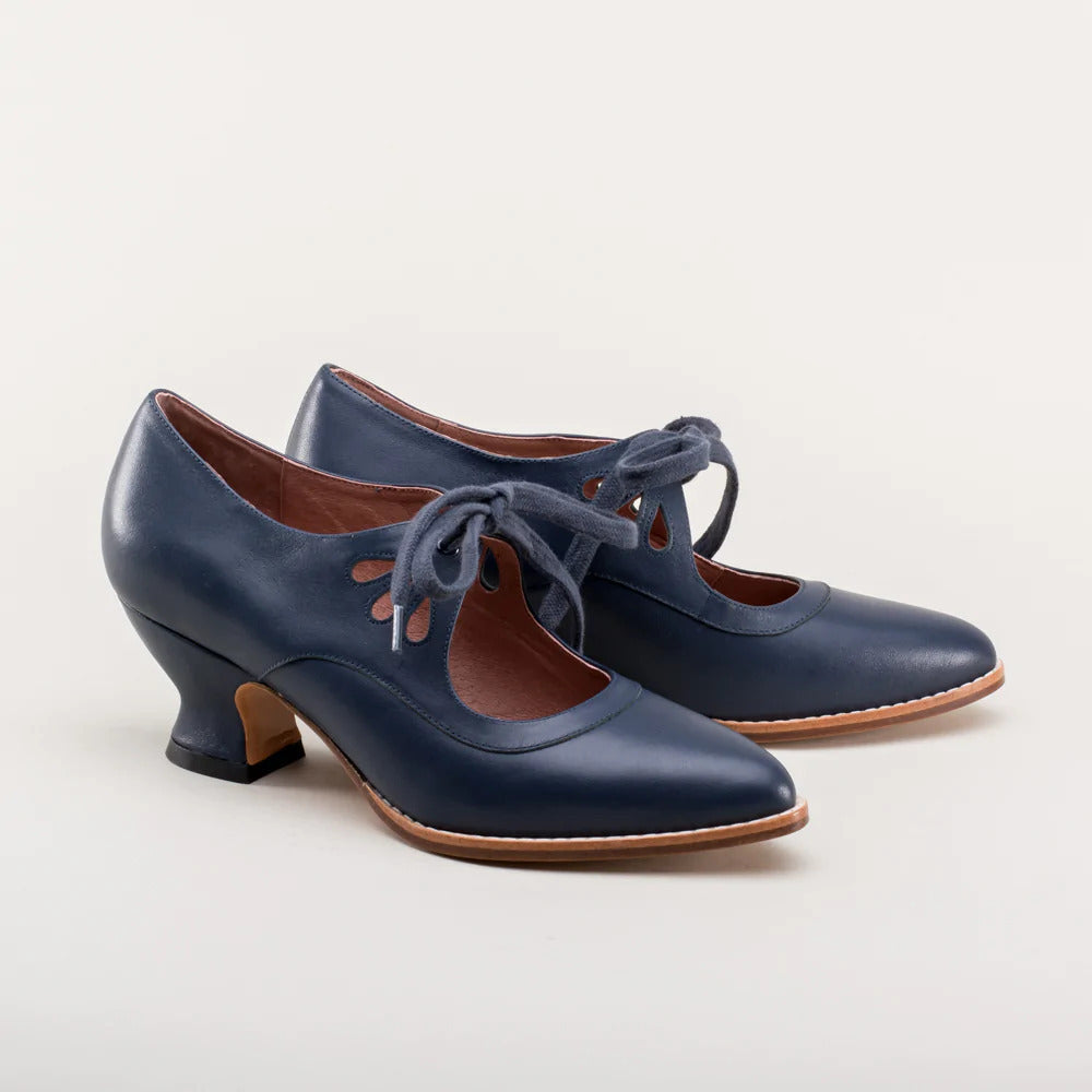 Scarpe da donna blu in pelle con tacco medio, lacci decorativi e dettagli traforati. Eleganti e adatte per occasioni formali e casual.