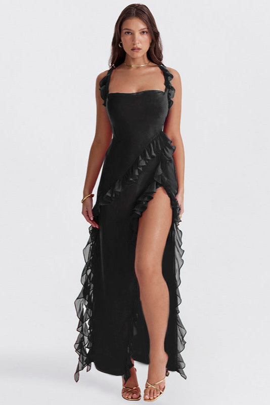 Donna in abito nero elegante con spacco alto e volant, sandali dorati. Moda serale, abbigliamento femminile sofisticato, stile glamour.