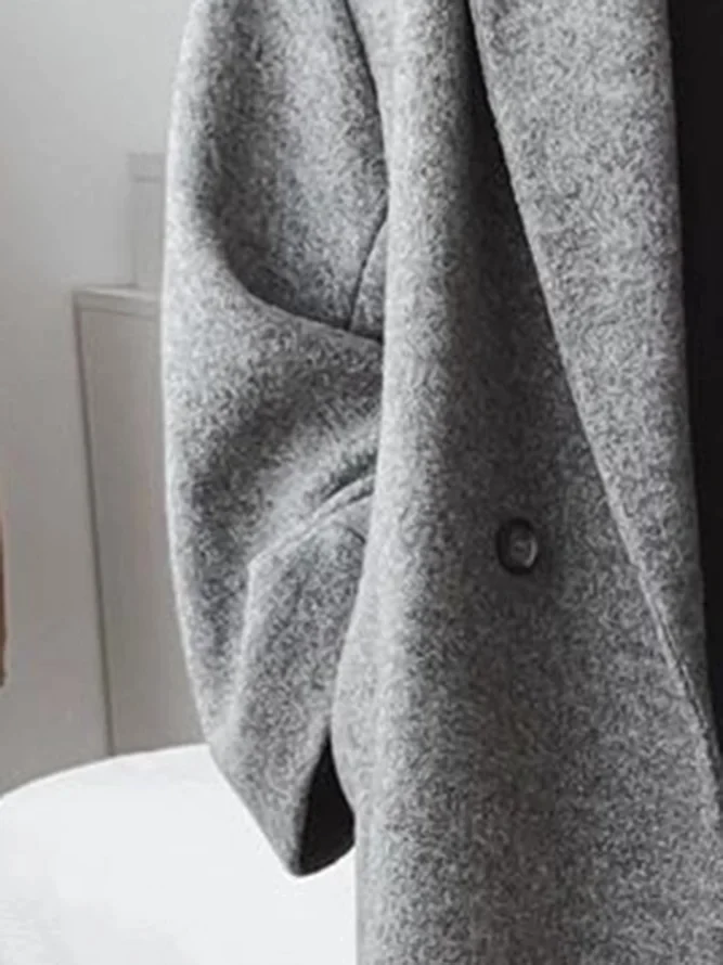 Cappotto grigio in lana, elegante e moderno, con bottone visibile. Perfetto per moda invernale e abbigliamento casual chic.