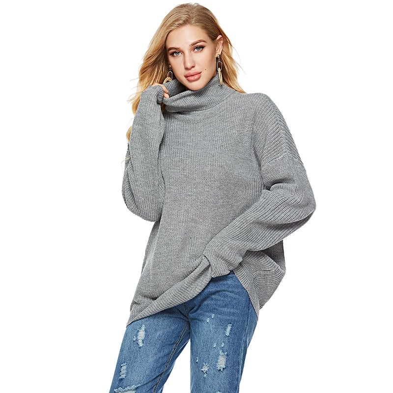Donna con maglione grigio a collo alto e jeans strappati. Moda autunnale, abbigliamento casual, stile confortevole.