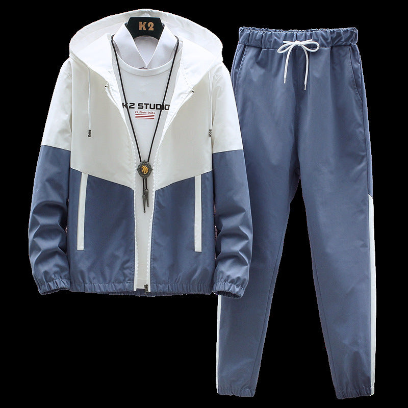 Tuta sportiva uomo bianca e blu, giacca con cappuccio e pantaloni con elastico, stile casual, ideale per attività all'aperto e tempo libero.