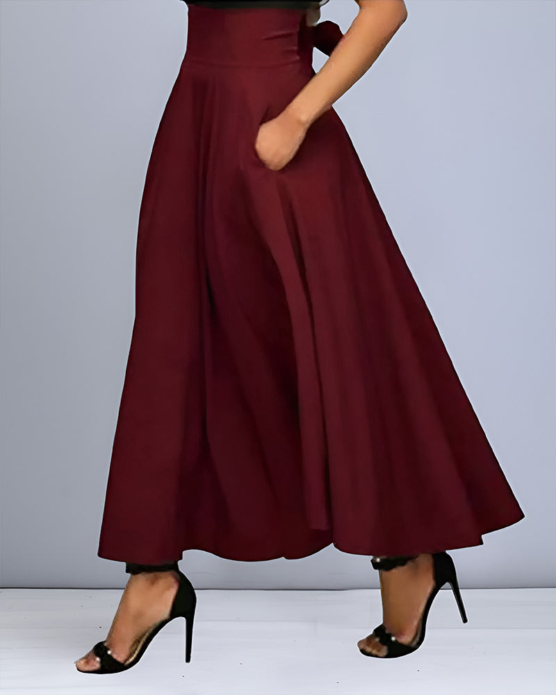 Pantaloni palazzo bordeaux eleganti, vita alta, con tasche, indossati con sandali neri con tacco. Moda donna, abbigliamento chic e sofisticato.