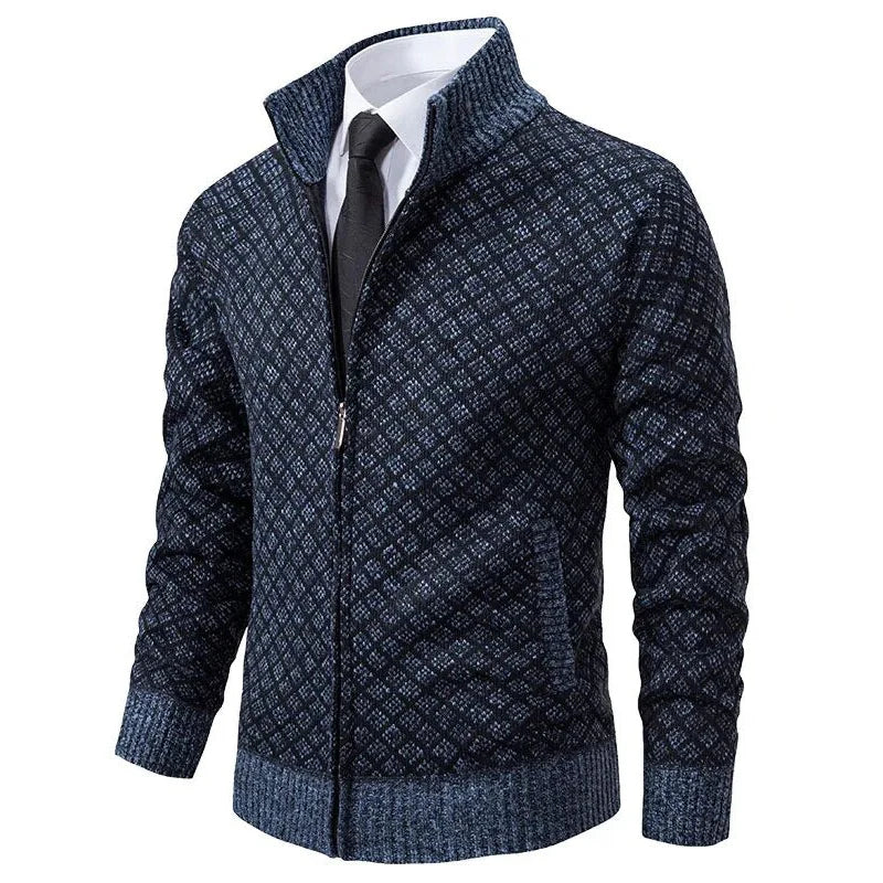 Giacca cardigan uomo blu scuro con motivo geometrico, zip frontale, colletto alto, abbinata a camicia bianca e cravatta nera. Moda elegante maschile.
