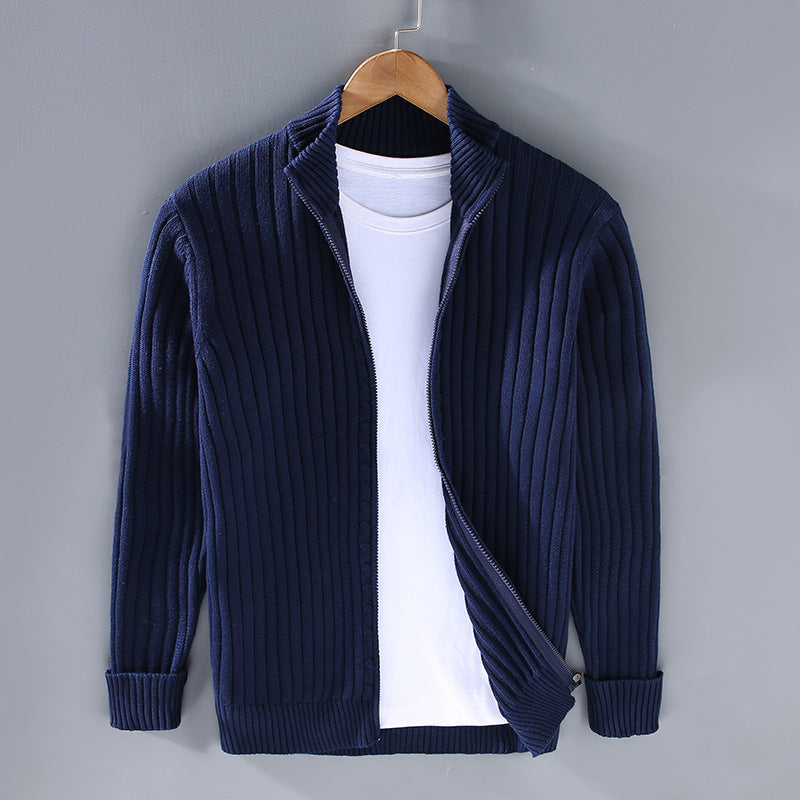 Cardigan blu a coste appeso su gruccia, con maglietta bianca sotto. Moda uomo, abbigliamento casual, stile autunnale, tessuto caldo.