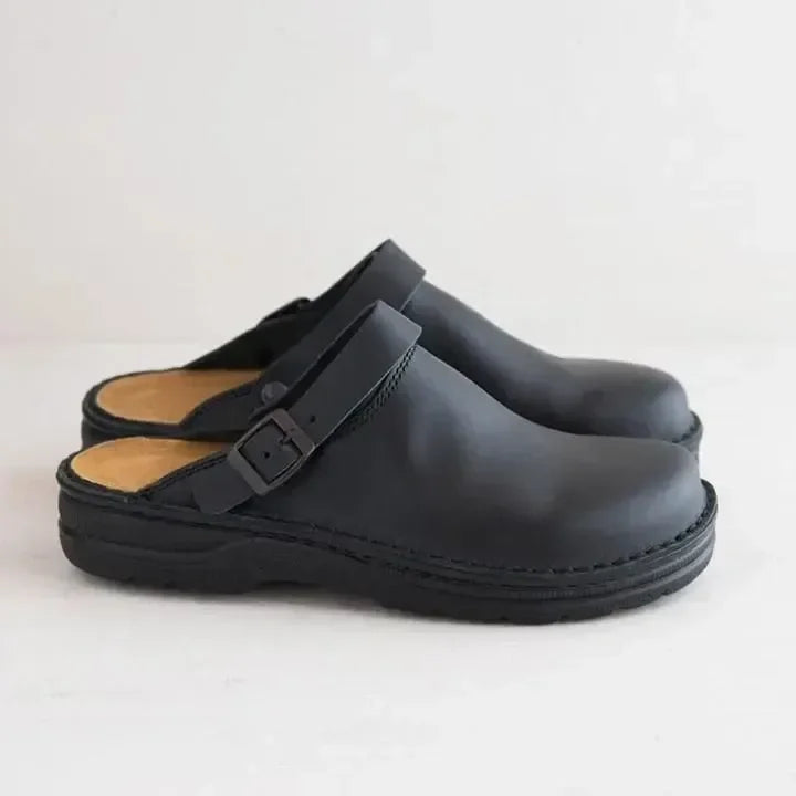 Zoccoli neri in pelle con cinturino regolabile, design minimalista, suola robusta. Scarpe comode per uso quotidiano, moda casual.