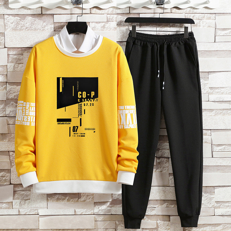 Completo sportivo uomo: felpa gialla con stampa grafica e pantaloni neri. Abbigliamento casual moderno, ideale per moda streetwear.