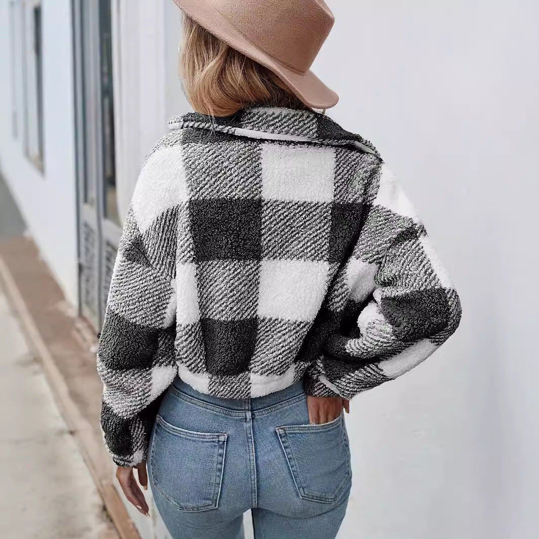 Donna di spalle con cappello beige, indossa giacca a quadri bianco-neri e jeans aderenti. Moda autunnale, stile casual chic, strada urbana.