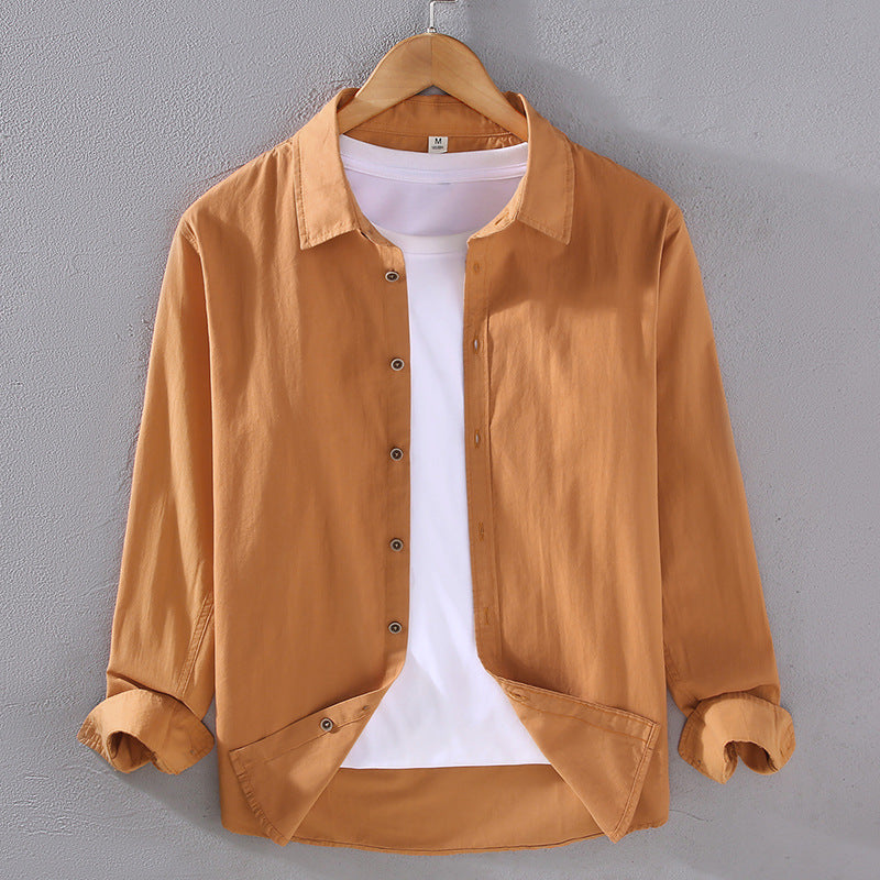 Camicia casual marrone chiaro da uomo su gruccia, con maniche lunghe e bottoni, sopra una maglietta bianca. Moda maschile, abbigliamento casual.