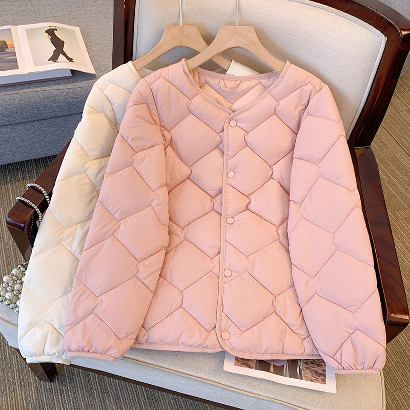 Giacca trapuntata rosa chiaro su sedia, design a rombi, bottoni frontali, accanto a giacca bianca. Moda autunnale, abbigliamento casual elegante.