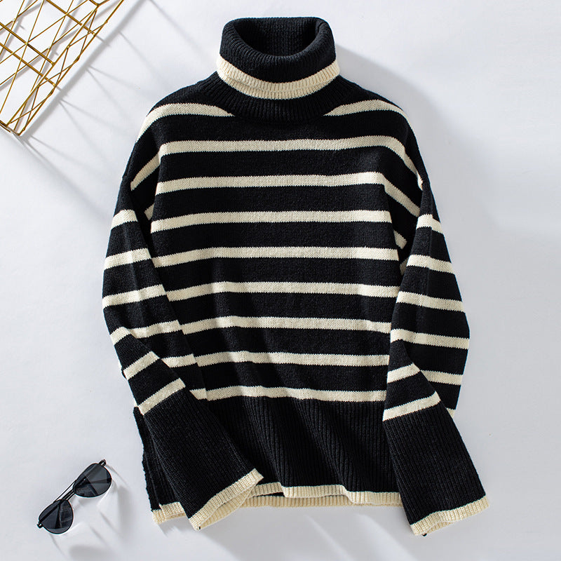 Maglione a righe bianche e nere con collo alto, stile casual, su sfondo bianco. Occhiali da sole neri accanto. Moda autunnale, abbigliamento invernale.