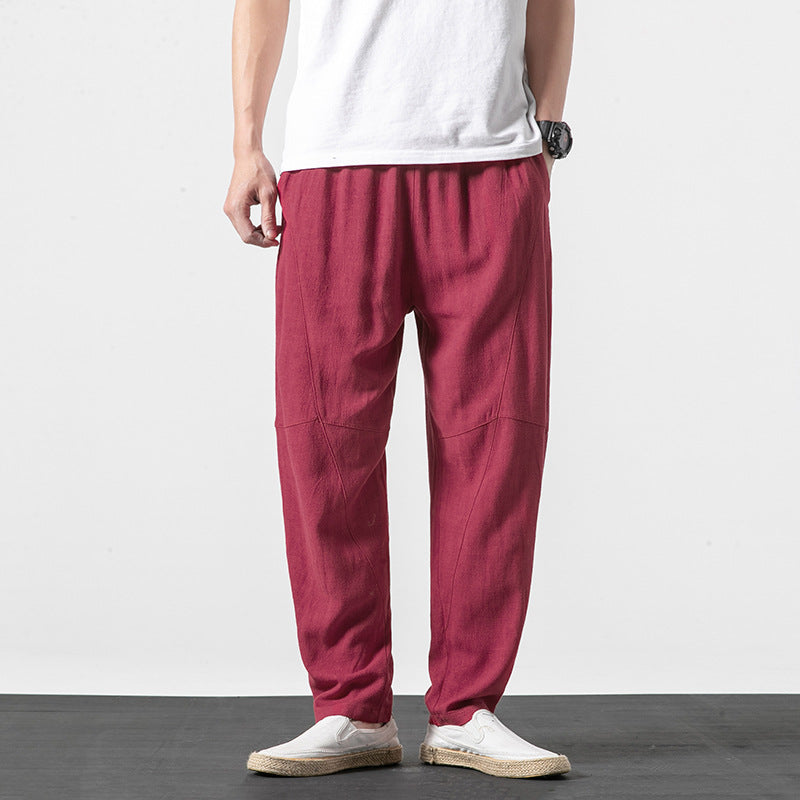 Pantaloni larghi uomo rossi, stile casual, indossati con t-shirt bianca e scarpe slip-on. Moda maschile estiva, abbigliamento comodo e trendy.