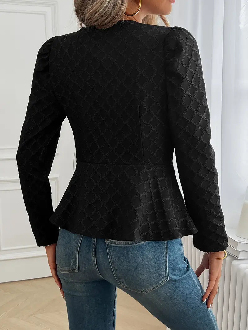 Giacca nera elegante con motivo a rombi, maniche lunghe e taglio peplum, indossata con jeans blu. Moda donna, abbigliamento autunnale chic.