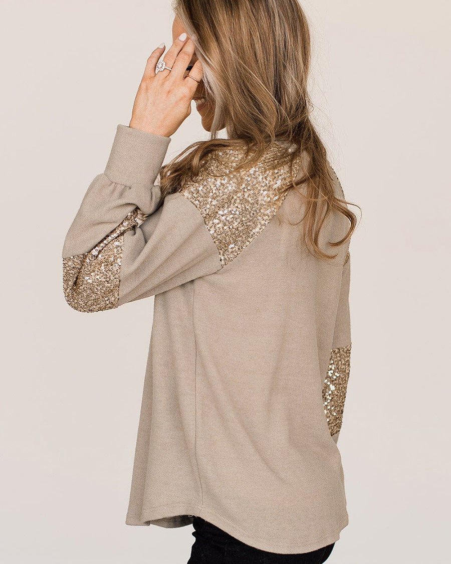 Donna con maglia beige a maniche lunghe con paillettes dorate, vista laterale. Moda autunno, abbigliamento casual elegante, stile glamour.