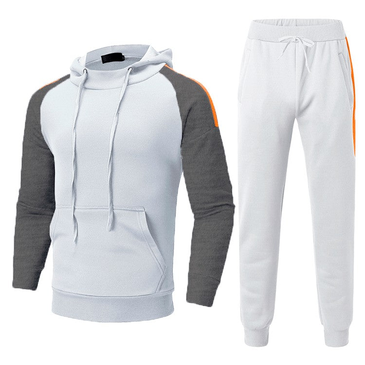 Tuta sportiva bianca e grigia con cappuccio, maniche a contrasto e dettagli arancioni. Completo casual per uomo, ideale per palestra e tempo libero.