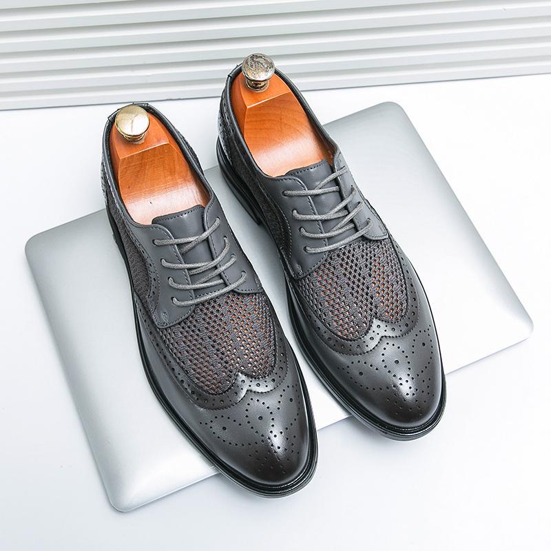 Scarpe eleganti in pelle nera traforata su laptop, design classico brogue, moda uomo, calzature di lusso, stile formale e sofisticato.