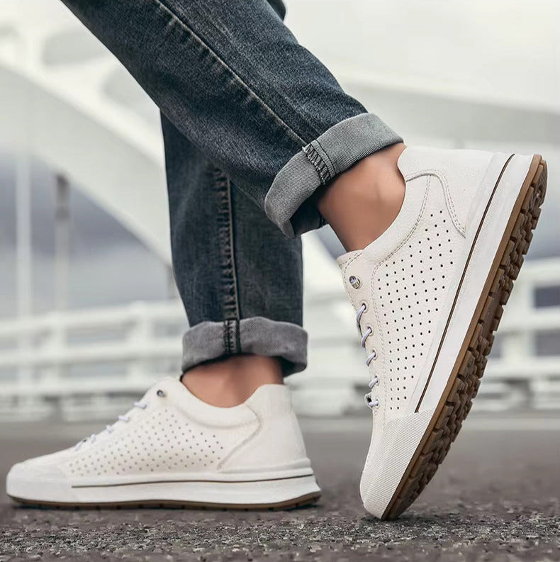 Scarpe da ginnastica bianche su sfondo urbano, indossate con jeans. Design moderno, suola in gomma, perfette per moda casual e comfort quotidiano.