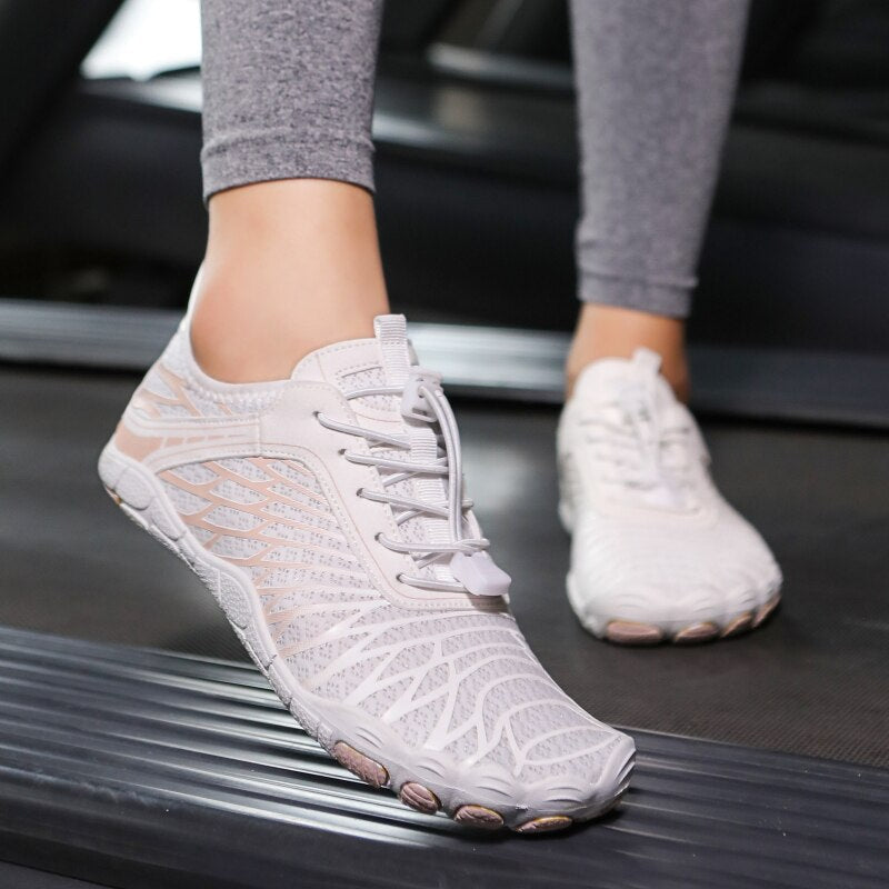 Scarpe da corsa minimaliste bianche su tapis roulant, design leggero e traspirante, ideali per fitness e allenamento indoor.