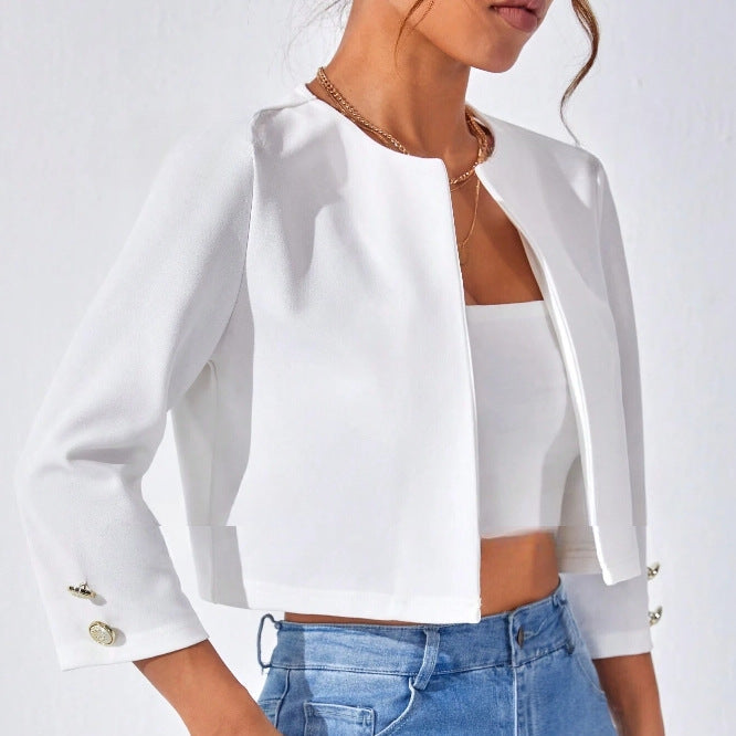Giacca corta bianca elegante, maniche a tre quarti, bottoni dorati, abbinata a top bianco e jeans. Moda donna, abbigliamento casual chic.