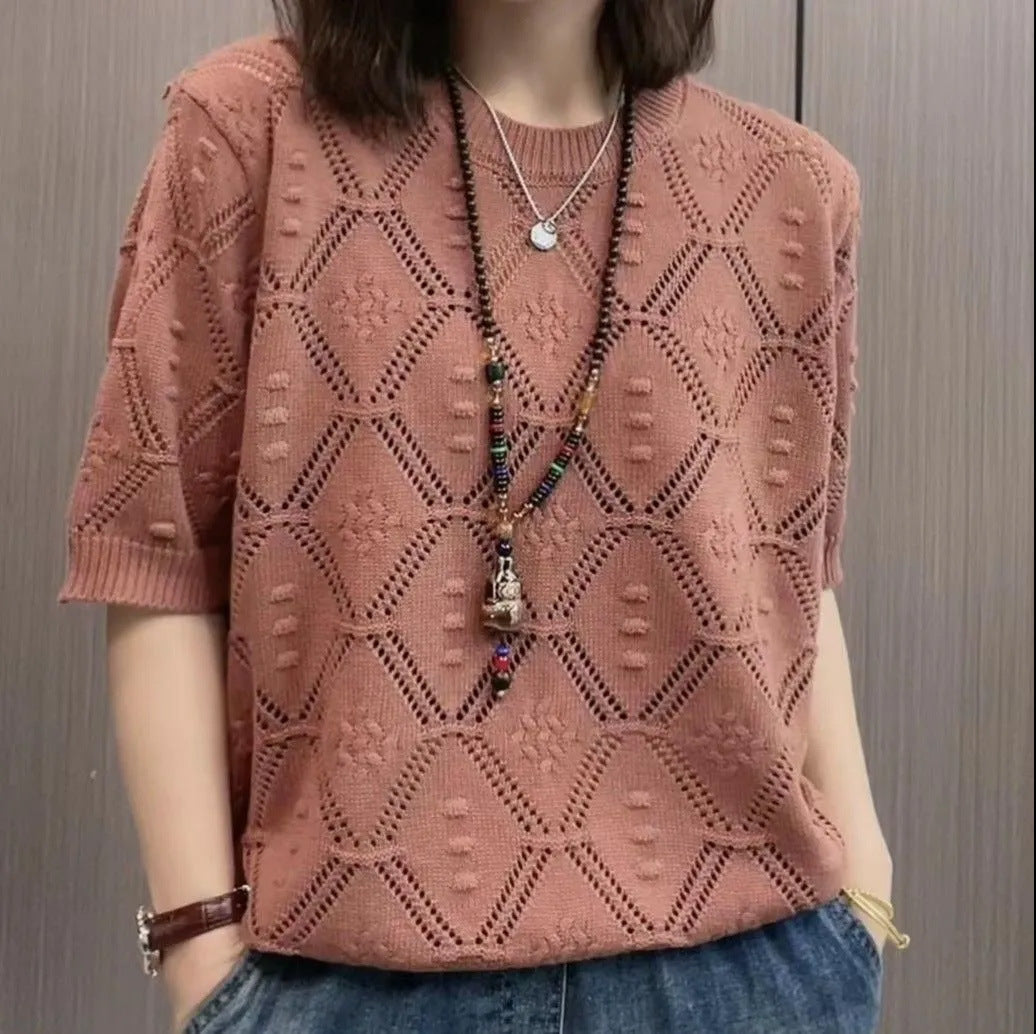Maglia rosa traforata con motivo geometrico, indossata con collana lunga e jeans. Moda casual donna, stile estivo, abbigliamento trendy.
