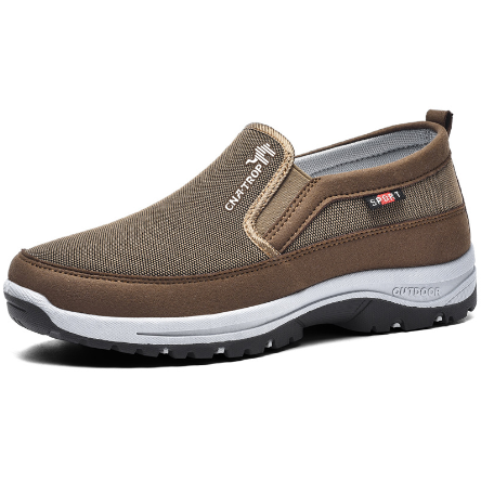 Scarpa slip-on marrone da uomo, tessuto traspirante, suola antiscivolo bianca e nera, ideale per camminate, comfort e stile casual.