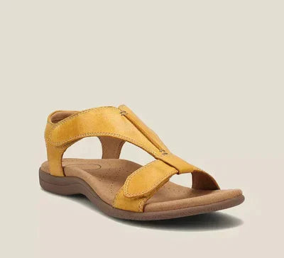 Sandalo giallo in pelle con suola ergonomica marrone, design aperto e cinturino regolabile. Calzature estive comode e alla moda.