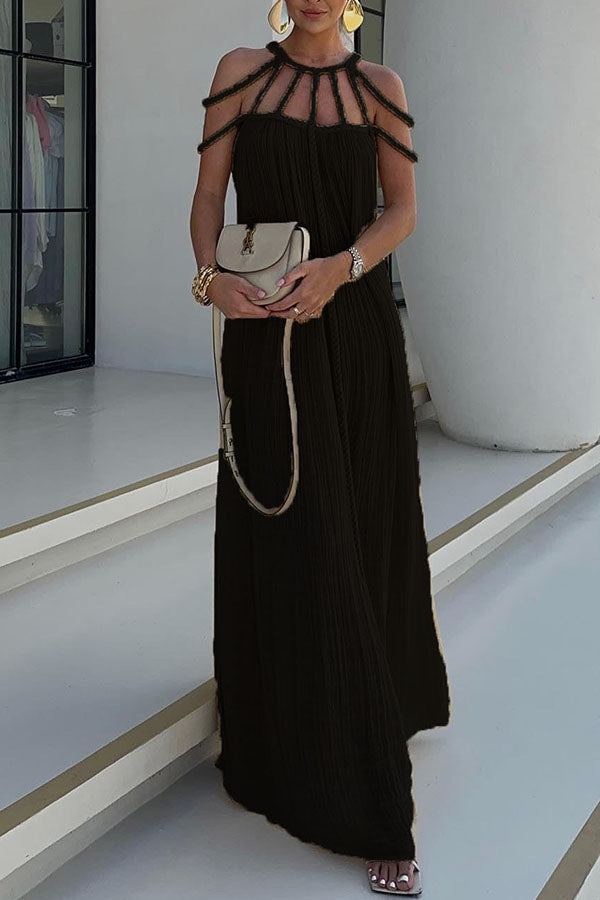 Donna con abito lungo nero elegante, dettagli a spalline, borsa a tracolla beige, bracciali dorati. Moda estiva, abbigliamento da sera chic.