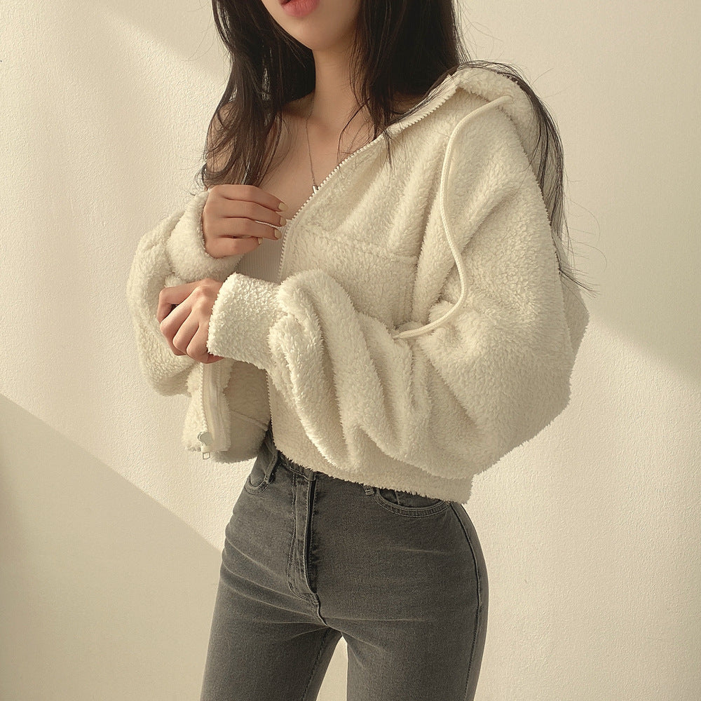 Donna con giacca in pile bianco e jeans grigi, posa alla moda. Abbigliamento casual autunnale, stile urbano, tendenze moda femminile.