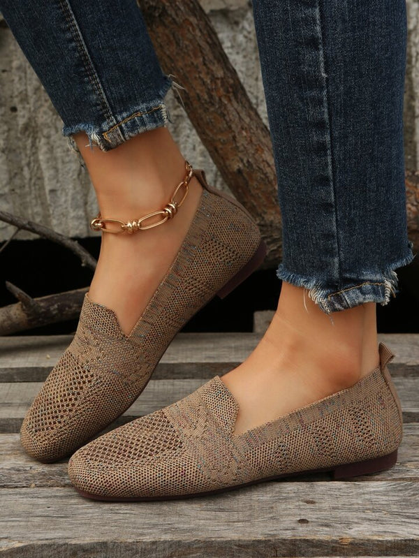 Scarpe mocassini intrecciati beige su piedi femminili con jeans strappati e cavigliera dorata. Moda casual, calzature eleganti, stile autunnale.