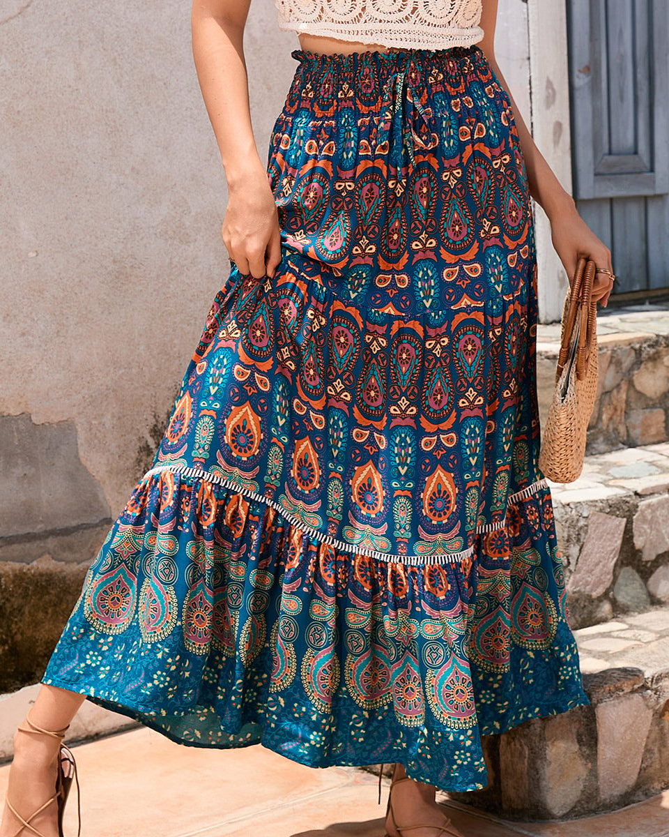 Gonna lunga boho con stampa paisley blu e arancione, vita alta elasticizzata, abbinata a top crochet bianco, moda estiva femminile.