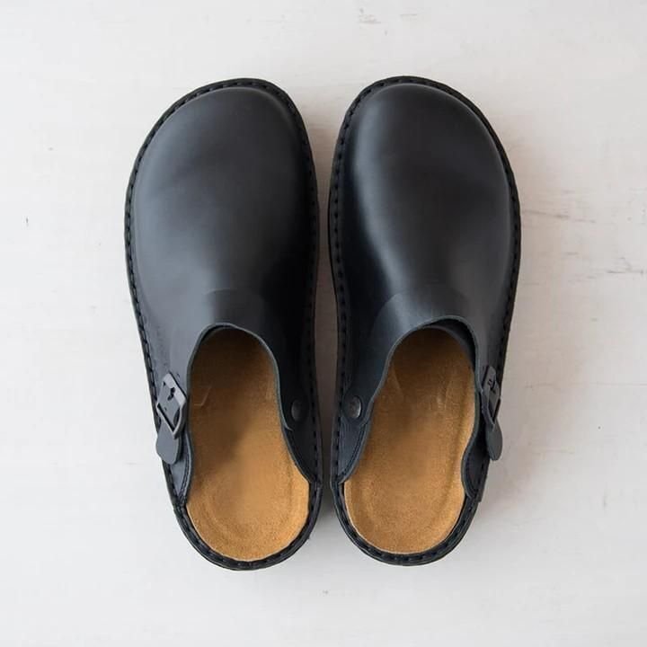 Scarpe sabot nere in pelle, design minimalista, suola interna marrone chiaro, chiusura laterale, viste dall'alto su sfondo bianco.