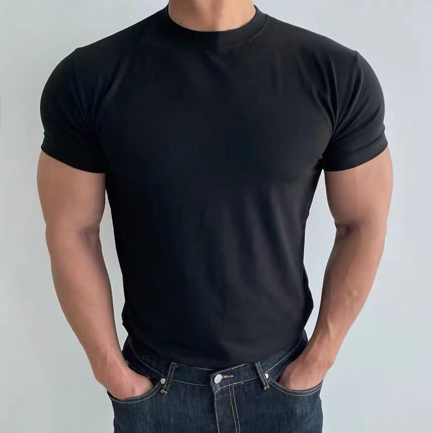 Uomo in t-shirt nera aderente, muscoloso, con jeans blu. Abbigliamento casual maschile, moda fitness, stile moderno.