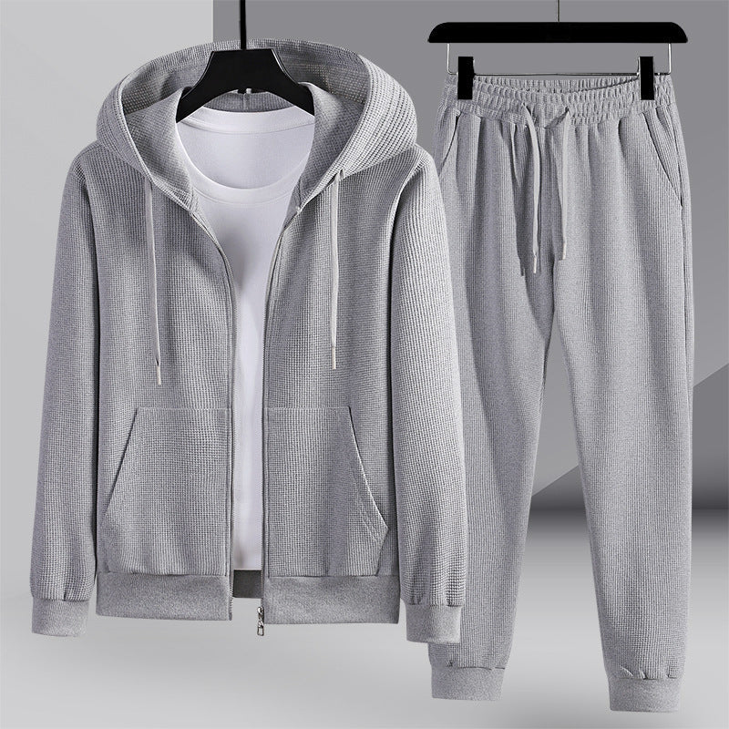 Tuta sportiva grigia da uomo con felpa con cappuccio e pantaloni, tessuto a coste, ideale per abbigliamento casual e sportivo.