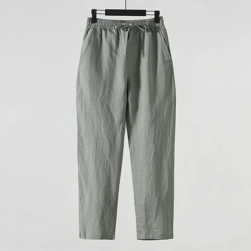 Pantaloni casual grigi da uomo in cotone, con elastico in vita e tasche laterali, appesi su gruccia. Abbigliamento comodo e versatile.