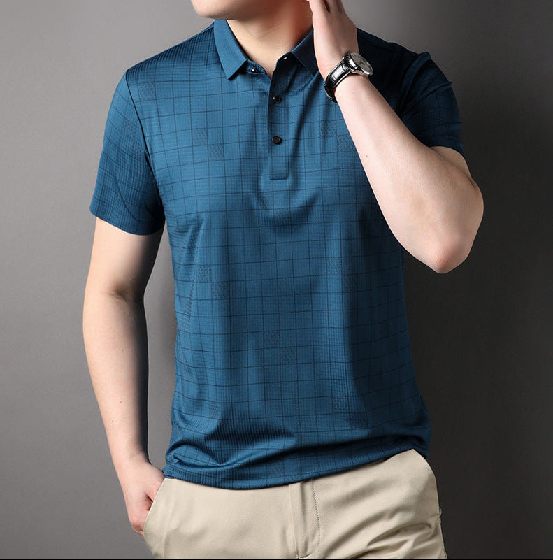 Uomo in polo blu a quadri, orologio al polso, pantaloni beige. Moda maschile casual, abbigliamento estivo elegante.