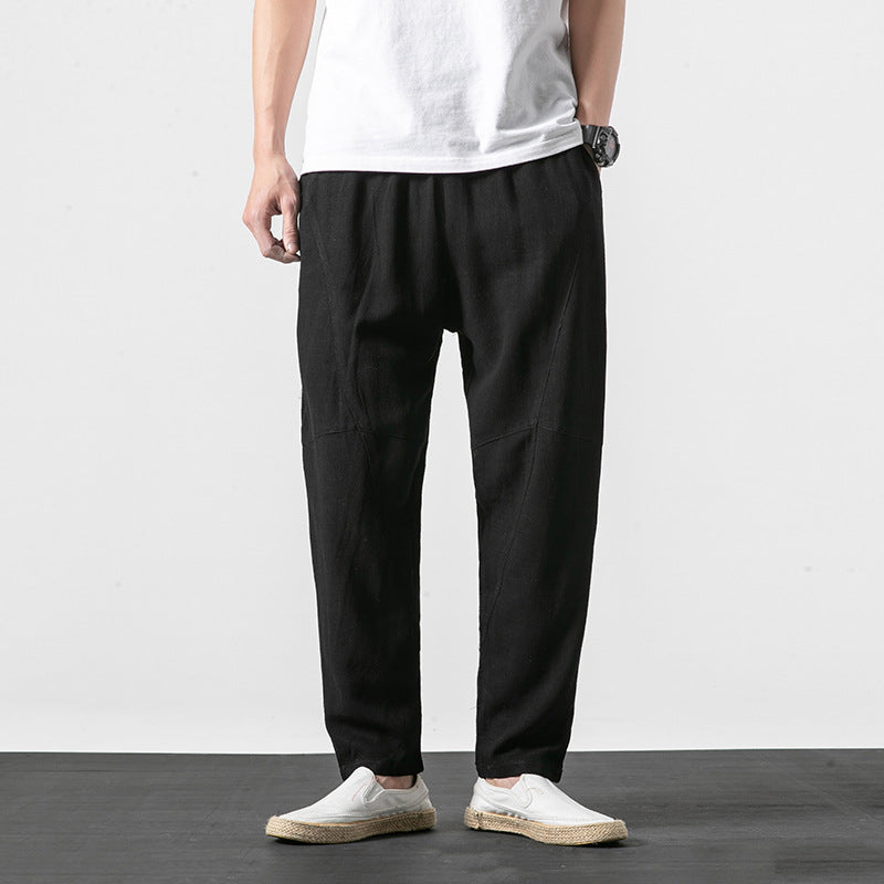 Uomo in pantaloni neri casual e scarpe bianche, indossa una maglietta bianca. Moda maschile minimalista, abbigliamento estivo elegante.