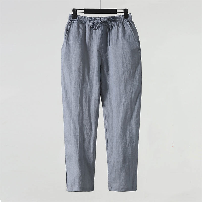 Pantaloni in lino grigio chiaro, stile casual, con coulisse in vita, appesi su gruccia. Ideali per look estivo e comfort quotidiano.
