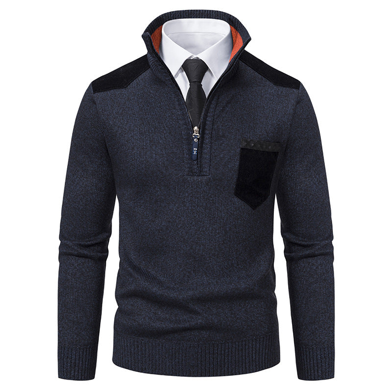 Maglione uomo blu scuro con zip, colletto alto, taschino e dettagli neri, indossato sopra camicia bianca e cravatta nera. Moda elegante autunno inverno.