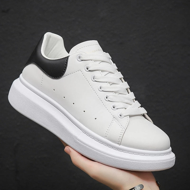 Scarpa da ginnastica bianca con suola spessa, dettagli neri sul tallone, design moderno e minimalista, perfetta per moda casual e streetwear.