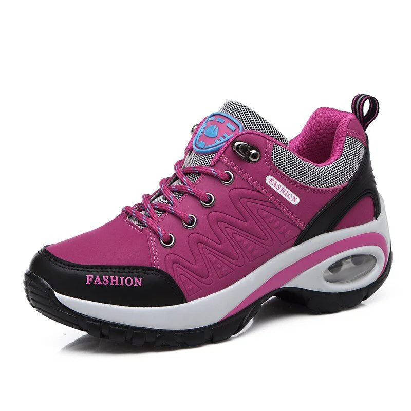 Scarpa da ginnastica rosa e nera con suola ammortizzata, dettagli in mesh e lacci, ideale per sport e moda casual.