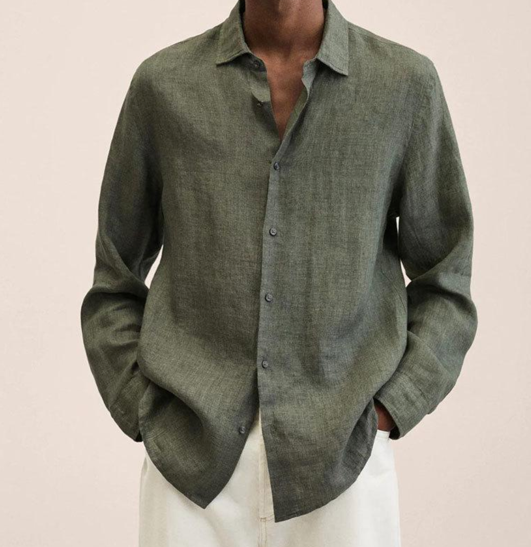 Camicia uomo in lino verde oliva, maniche lunghe, abbinata a pantaloni bianchi. Moda maschile elegante e casual, stile estivo.
