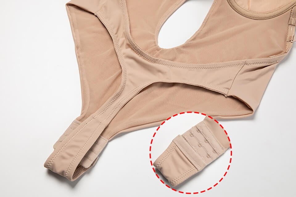 Body shaper beige con chiusura regolabile a ganci, tessuto elastico e design ergonomico. Indumento modellante per silhouette perfetta.