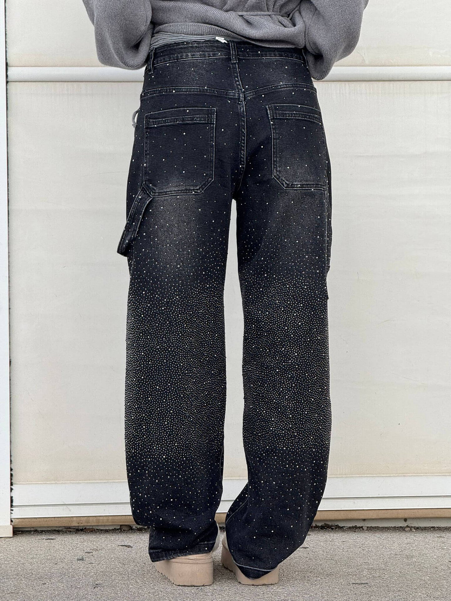 Jeans neri con dettagli scintillanti, tasche posteriori e vestibilità ampia. Moda casual, stile urbano, abbigliamento trendy.