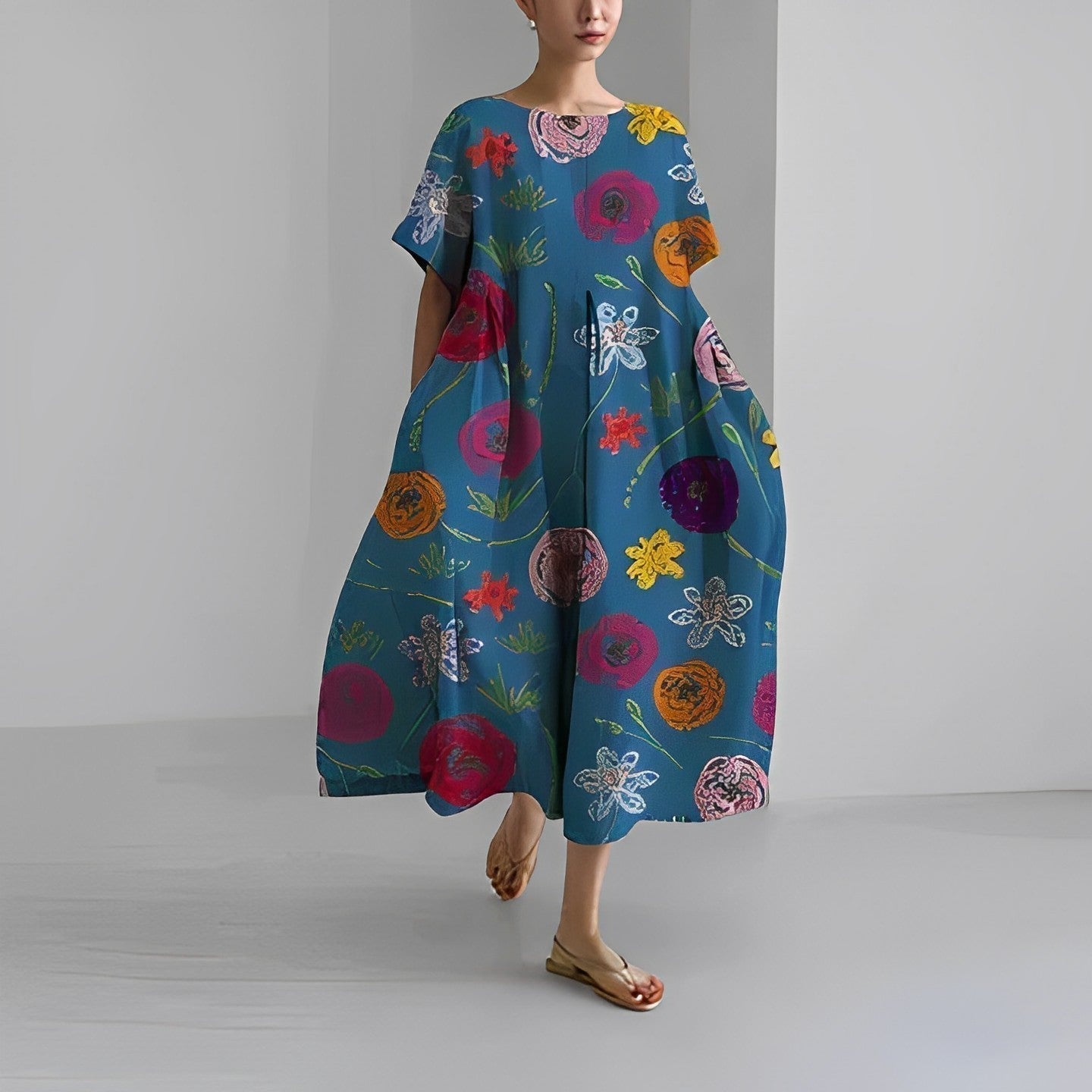 Abito lungo estivo blu con motivi floreali colorati, indossato da una donna. Moda femminile, abbigliamento casual elegante, tendenze 2023.