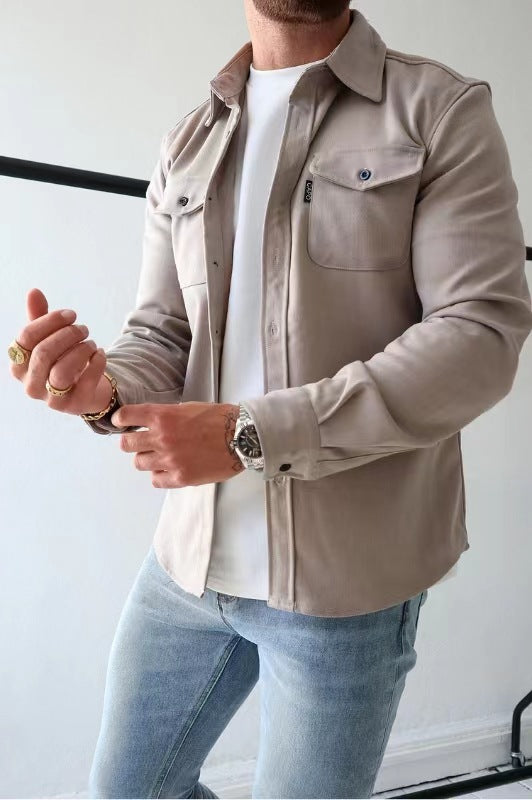 Uomo con camicia beige e jeans chiari, indossa orologio e anelli. Moda casual maschile, stile moderno, abbigliamento trendy.