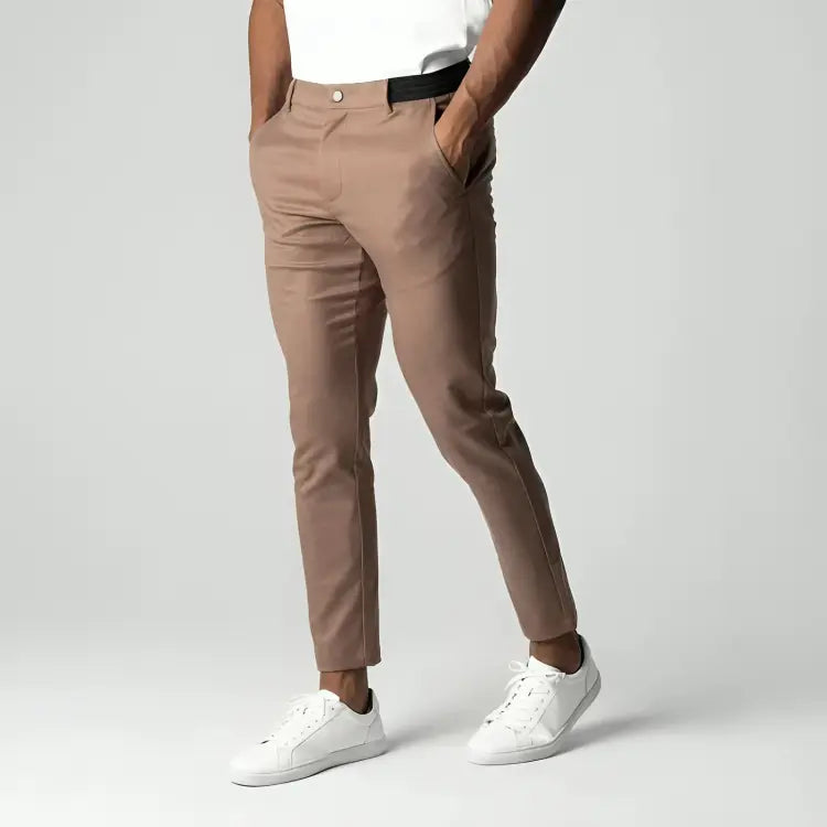 Pantaloni chino beige da uomo, eleganti e moderni, abbinati a scarpe bianche e maglietta bianca. Stile casual, moda maschile contemporanea.