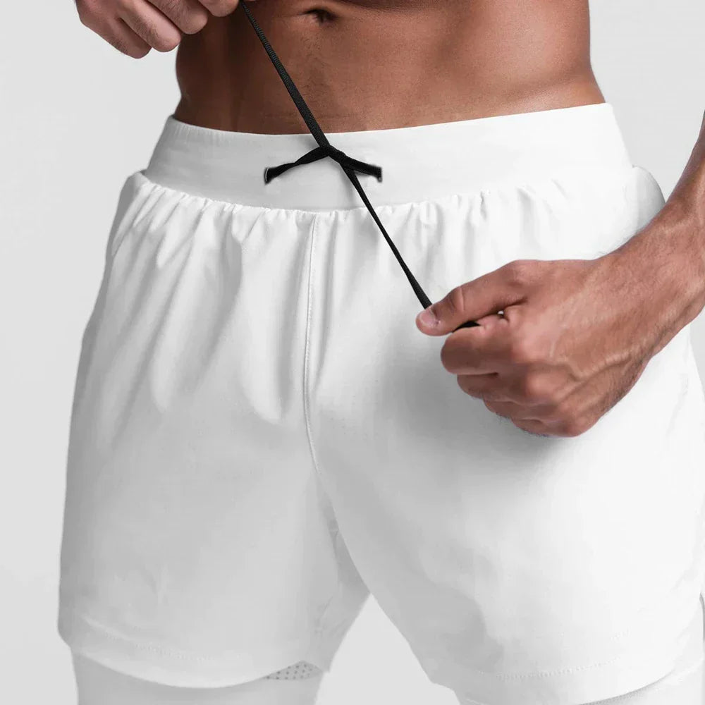 Uomo in pantaloncini sportivi bianchi regola il laccio. Abbigliamento fitness maschile, moda sportiva, pantaloncini da allenamento.