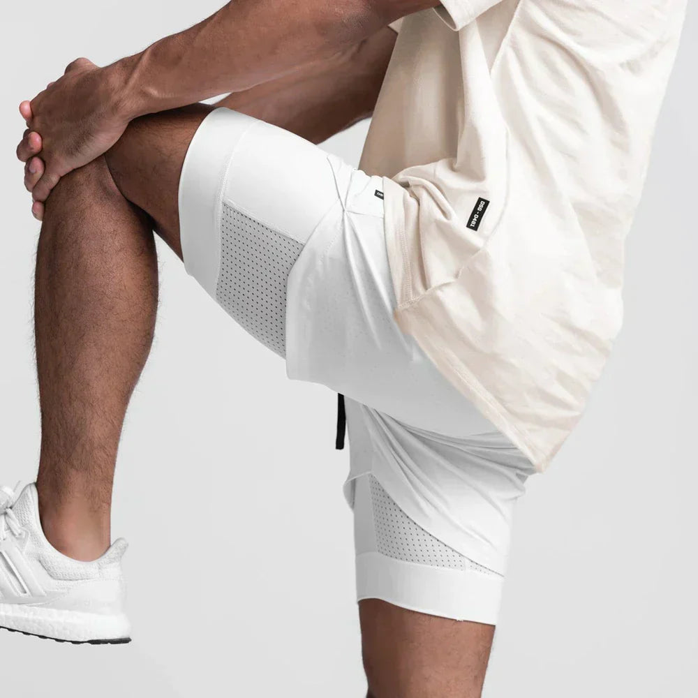 Uomo in abbigliamento sportivo bianco, indossa pantaloncini e scarpe da ginnastica, posa in movimento. Fitness, moda sportiva, abbigliamento atletico.